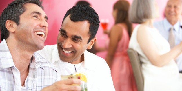 Two mature men having drinks and laughing in lounge