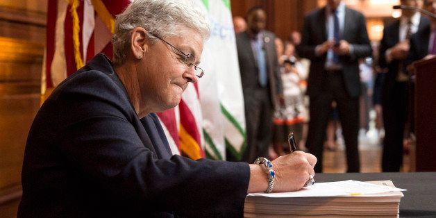 Environmental Protection Agency (EPA) Administrator Gina McCarthy signs a proposal under the Clean Air Act to cut carbon pollution from existing power plants during a news conference in Washington June 2, 2014. The U.S. power sector must cut carbon dioxide emissions 30 percent by 2030 from 2005 levels, according to federal regulations unveiled on Monday that form the centerpiece of the Obama administration's climate change strategy. REUTERS/Joshua Roberts (UNITED STATES - Tags: POLITICS ENERGY ENVIRONMENT TPX IMAGES OF THE DAY)