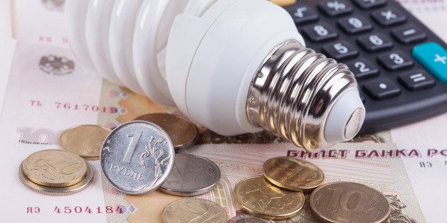 Energy saving concept. Electric light bulb with dollar bills, pen and calculator