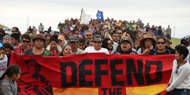 Native Americans march to a burial ground sacred site that was disturbed by bulldozers building the Dakota Access Pipeline (DAPL), near the encampment where hundreds of people have gathered to join the Standing Rock Sioux Tribe's protest of the oil pipeline that is slated to cross the Missouri River nearby, September 4, 2016 near Cannon Ball, North Dakota.Protestors were attacked by dogs and sprayed with an eye and respiratory irritant yesterday when they arrived at the site to protest after learning of the bulldozing work. / AFP / Robyn BECK (Photo credit should read ROBYN BECK/AFP/Getty Images)