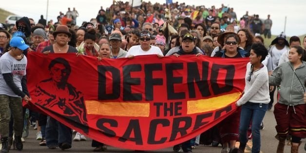 Native Americans march to the site of a sacred burial ground that was disturbed by bulldozers building the Dakota Access Pipeline (DAPL), near the encampment where hundreds of people have gathered to join the Standing Rock Sioux Tribe's protest of the oil pipeline slated to cross the nearby Missouri River, September 4, 2016 near Cannon Ball, North Dakota. Protestors were attacked by dogs and sprayed with an eye and respiratory irritant yesterday when they arrived at the site to protest after learning of the bulldozing work. / AFP / ROBYN BECK (Photo credit should read ROBYN BECK/AFP/Getty Images)