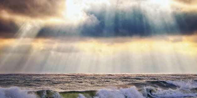Glorious sky with sun rays beaming over the ocean and waves at Robert Moses State Park, Babylon, Long Island.