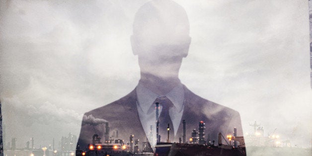 Double exposure of businessman and power plant