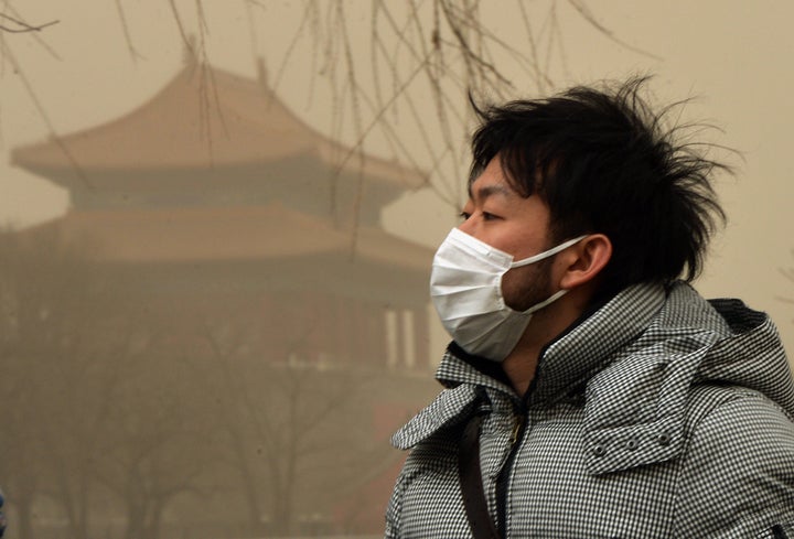 A Chinese man wears a facemask as Beijing is hit by a sandstorm as well as air quality worse than the highest classification of 'hazardous' on February 28, 2013. Beijing residents were urged to stay indoors on February 28 as pollution levels soared before a sandstorm brought further misery to China's capital. AFP PHOTO/Mark RALSTON (Photo credit should read MARK RALSTON/AFP/Getty Images)