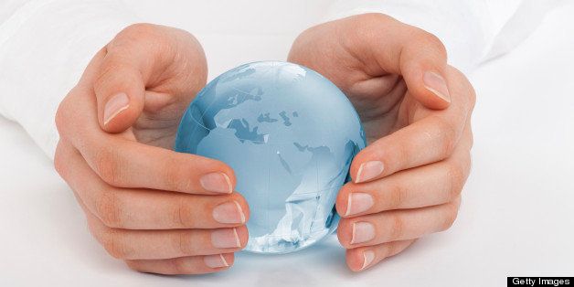 Hands of a woman protecting a globe.
