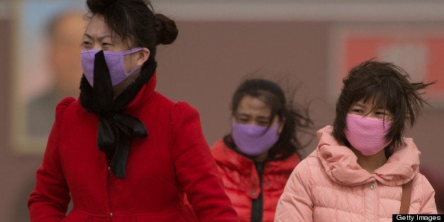 Chinese women cover their noses as Beijing is hit by a sandstorm as well as air quality worse than the highest classification of 'hazardous' on February 28, 2013. Beijing residents were urged to stay indoors Thursday as pollution levels soared before a sandstorm brought further misery to China's capital. AFP PHOTO / Ed Jones (Photo credit should read Ed Jones/AFP/Getty Images)