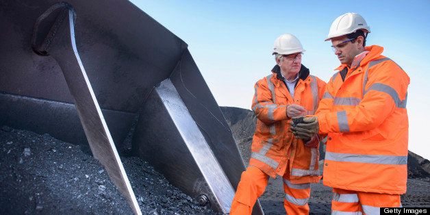 Workers inspecting coal at surface mine