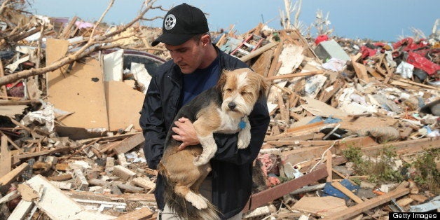 MOORE, OK - MAY 21: Sean Xuereb recovers a dog from the rubble of a home that was destroyed by a tornado on May 21, 2013 in Moore, Oklahoma. The town reported a tornado of at least EF4 strength and two miles wide that touched down yesterday killing at least 24 people and leveling everything in its path. U.S. President Barack Obama promised federal aid to supplement state and local recovery efforts. (Photo by Scott Olson/Getty Images)