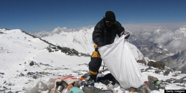 This picture taken on May 23, 2010 shows a Nepalese sherpa collecting garbage, left by climbers, at an altitude of 8,000 metres during the Everest clean-up expedition at Mount Everest. A group of 20 Nepalese climbers, including some top summiteers collected 1,800 kilograms of garbage in a high-risk expedition to clean up the world's highest peak. Led by seven-time summiteer Namgyal Sherpa, the team braved thin air and below freezing temperatures to clear around two tonnes of rubbish left behind by mountaineers, that included empty oxygen cylinders and corpses. Since 1953, there have been some 300 deaths on Everest. Many bodies have been brought down, but those above 8,000 metres have generally been left to the elements -- their bodies preserved by the freezing temperatures. The priority of the sherpas had been to clear rubbish just below the summit area, but coordinator Karki said large quantities of refuse was collected from 8,000 meters and below. AFP PHOTO/Namgyal SHERPA (Photo credit should read NAMGYAL SHERPA/AFP/Getty Images)