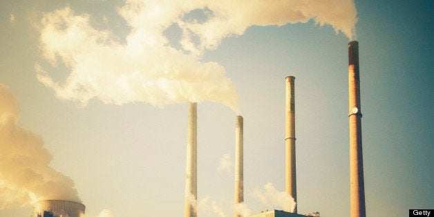 Power station with smoking chimneys in 70's retro look. Toned image with added grain.