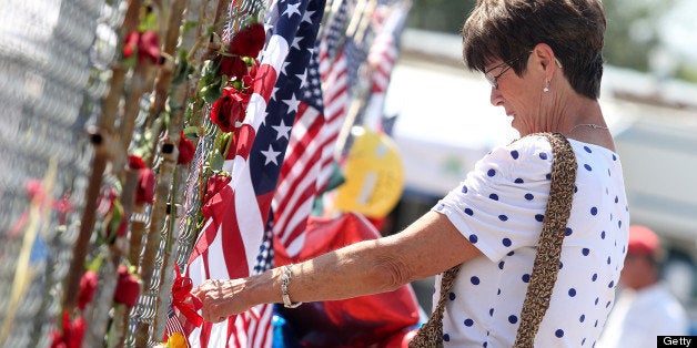 Nancy Alder pays her respects at the memorial for the 19 fallen Granite Mountain Hotshot firefighters outside of fire station 7 in Prescott, Arizona July 2, 2013. The Yarnell Hill fire -- which killed all but one member of a 20-strong 'hotshot' team -- was the biggest loss of firefighters' lives since the September 11 attacks, and the most from a US wildfire in 80 years. AFP PHOTO / KRISTA KENNELL (Photo credit should read Krista Kennell/AFP/Getty Images)