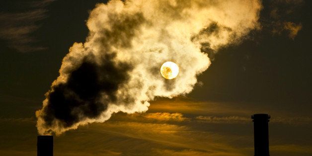 Wads of smoke from chimney eclipsing the sun, contre-jour photograph