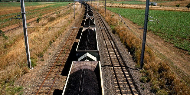 coal train on railway tracks in rural landscape