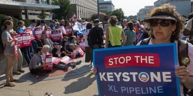 About 200 activists stage a sit-in outside the US State Department in opposition to the Keystone XL pipeline in an attempt to maintain pressure on President Obama to keep his promise to fight climate change by rejecting the Keystone XL pipeline, August 12, 2013, in Washington, DC. AFP Photo/Paul J. Richards (Photo credit should read PAUL J. RICHARDS/AFP/Getty Images)