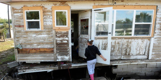 LASALLE, CO - SEPTEMBER 19: Michelle Toubeaux checks out the damage to her home in LaSalle, September 19, 2013. A folding chair is the only thing keeping up part of the home's foundation. Residents start to clean up after a massive flood hit the area. (Photo By RJ Sangosti/The Denver Post via Getty Images)