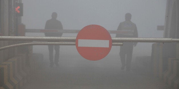 A toll booth is shuttered as heavy smog spreads on a highway as vehicles are forced to wait due to heavy smog in Jilin, north