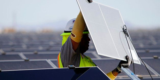 A worker installs First Solar Inc. photovoltaic solar panels at the Agua Caliente Solar Project in Yuma County, Arizona, U.S., on Wednesday, Feb. 16, 2012. Arizona will hold its Republican presidential primary on Feb. 28. Photographer: Joshua Lott/Bloomberg via Getty Images