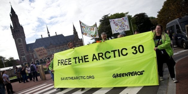 Greenpeace activists and supporters protest during a solidarity march for 30 activists jailed by Russia, from the Russian embassy to the Peace Palace in The Hague on October 5, 2013. Greenpeace supporters held vigils across the world Saturday in support of 30 activists jailed by Russia after a protest against Arctic oil drilling, sparking a new row between Moscow and the West. AFP PHOTO/ ANP/ JERRY LAMPEN netherlands out (Photo credit should read JERRY LAMPEN/AFP/Getty Images)