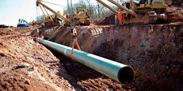 A sixty-foot section of pipe is lowered into a trench during construction of the Gulf Coast Project pipeline in Prague, Oklahoma, U.S., on Monday, March 11, 2013. The Gulf Coast Project, a 485-mile crude oil pipeline being constructed by TransCanada Corp., is part of the Keystone XL Pipeline Project and will run from Cushing, Oklahoma to Nederland, Texas. Photographer: Daniel Acker/Bloomberg via Getty Images