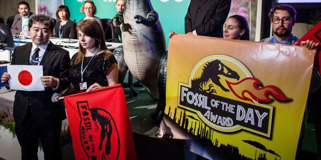 Action Network (CAN) activist is seen during CAN press conferance at United Nations Climate Change COP19 as she announces that Fossil of the Day Award goes to Japan in reaction after Japan decision to slashing its goal for reducing climate-altering carbon emissions during CAN press conferance at United Nations Climate Change COP19, on November 15, 2013. Europe and the world's small island nations reacted with dismay, and green groups with fury, after Japan on Friday slashed its goal for curbing carbon emissions. AFP PHOTO WOJTEK RADWANSKI (Photo credit should read WOJTEK RADWANSKI/AFP/Getty Images)