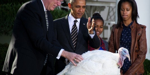 US President Barack Obama (2nd L) gestures with his daughters Sasha (2nd R) and Malia (R) in the Rose Garden of the White Ho