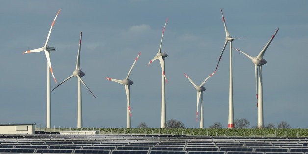 WERDER, GERMANY - OCTOBER 30: Wind turbines stand behind a solar power park on October 30, 2013 near Werder, Germany. The German Social Democrats (SPD) and Christian Democrats (CDU and CSU) are currently in the midst of negotiations to form a new German government and renewable energy policy is among their main points of discussion. (Photo by Sean Gallup/Getty Images)