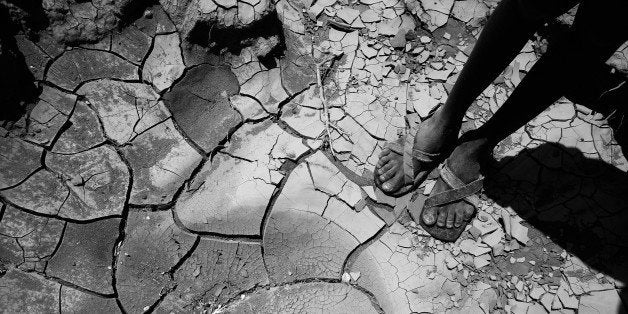 LODWAR, KENYA - NOVEMBER 09: A young boy from the remote Turkana tribe in Northern Kenya stands on a dried up river bed on November 9, 2009 near Lodwar, Kenya. Over 23 million people across East Africa are facing a critical shortage of water and food, a situation made worse by climate change. The traditional nomadic life of the pastoralist is coming under increasing pressure in northern Kenya from repeated droughts and political marginalisation. As a result, communities are forced to settle near the remaining water sources, overburdening the scarce reserves. Oxfam are responding to this crisis with a programme of water and food aid, distributed through relief centres in the region.(Photo by Christopher Furlong/Getty Images)