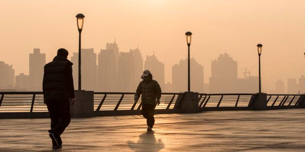 SHANGHAI, CHINA - DECEMBER 25: (CHINA OUT) People walk at The Bund as heavy smog engulfs the city on December 25, 2013 in Shanghai, China. Heavy smog covered many parts of China on Christmas Eve, worsening air pollution. (Photo by ChinaFotoPress/ChinaFotoPress via Getty Images)