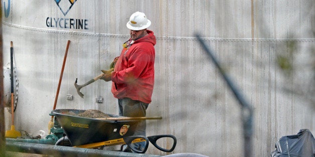 CHARLESTON, WV - JANUARY 10: An unidentified worker at Freedom Industries shovels NAPA premium oil absorbent on January 10,