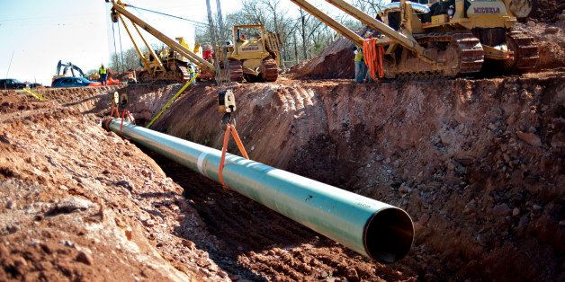A sixty-foot section of pipe is lowered into a trench during construction of the Gulf Coast Project pipeline in Prague, Oklahoma, U.S., on Monday, March 11, 2013. The Gulf Coast Project, a 485-mile crude oil pipeline being constructed by TransCanada Corp., is part of the Keystone XL Pipeline Project and will run from Cushing, Oklahoma to Nederland, Texas. Photographer: Daniel Acker/Bloomberg via Getty Images
