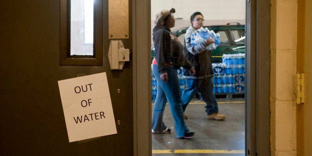 CHARLESTON, WV JANUARY 11, 2014:An out of water sign sits on the inside of a door, out of view when water is available, as residents carry cases of water out of the at Charleston Fire Department Station One where police officers and fire fighters were handing out cases of water to those in need in Charleston, West Virginia on Saturday, January 11, 2014. Around 5000 gallons of a chemical, used in the coal cleaning process, leaked into the Elk River from the West Virginia American Company and has stopped the usage of tap water for 300,000 West Virginia residents in nine different counties.Ty Wright for the Washington Post