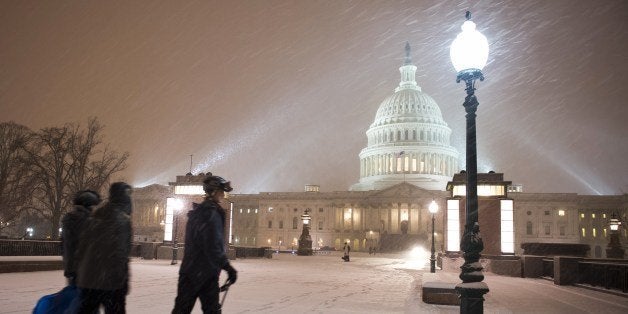 A young man on skis and his friends pass in front of the US Congress building as a heavy snow storm hits Washington D.C. on February 13, 2014. The eastern US, in the grips of one of the most brutal winters in recent memory, braced for what forecasters warned could be the worst broadside yet -- a massive storm with the season's heaviest snowfall. AFP PHOTO / MLADEN ANTONOV (Photo credit should read MLADEN ANTONOV/AFP/Getty Images)