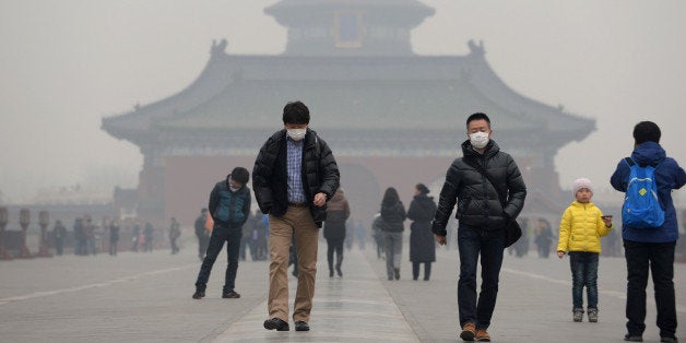 This picture taken on February 24, 2014 shows visitors wearing masks in Temple of Heaven in haze-covered Beijing. Dangerous smog which has blighted swathes of northern China in recent days has prompted a spike in air purifier sales, local media reported Monday, as pollution continued to shroud Beijing. China's National Meteorological Centre issued a 'yellow' smog alert for much of the country's north on Monday, the fifth consecutive day of heavy pollution which has slashed visibility and seen pollution reach hazardous levels. CHINA OUT AFP PHOTO (Photo credit should read STR/AFP/Getty Images)