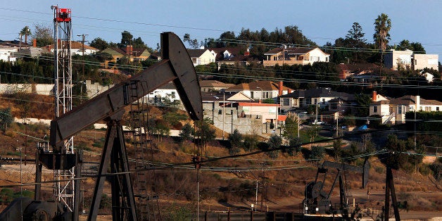 Homes stand while pumpjacks operate near a hydraulic fracturing (fracking) test well at the Inglewood Oil field in Los Angeles, California, U.S., on Thursday, Oct. 19, 2012. The Inglewood Oil Field is a steady source of domestic oil and natural gas as well as the second most productive oil field in the entire L.A. Basin. Photographer: Patrick T. Fallon/Bloomberg via Getty Images