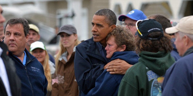 US President Barack Obama comforts Hurricane Sandy victim Dana Vanzant as he visits a neighborhood in Brigantine, New Jersey, on October 31, 2012. Americans sifted through the wreckage of superstorm Sandy on Wednesday as millions remained without power. The storm carved a trail of devastation across New York City and New Jersey, killing dozens of people in several states, swamping miles of coastline, and throwing the tied-up White House race into disarray just days before the vote. AFP PHOTO/Jewel Samad (Photo credit should read JEWEL SAMAD/AFP/Getty Images)