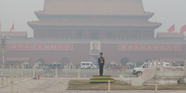 BEIJING, CHINA - MARCH 27: Security personnel stand guard at Tiananmen Square blanketed in smog on March 27, 2014 in Beijing