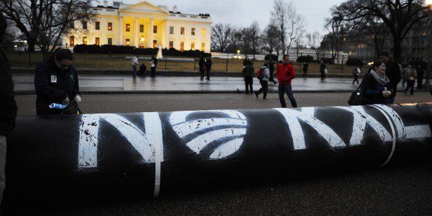 Environmental activists inflate a long balloon to mock a pipeline during a demonstration in front of the White House in Washington, DC, on February 3, 2014 to protest against the Keystone pipeline project. The US State Department last week released a long-awaited review of a controversial pipeline project to bring oil from Canada to Texas, suggesting it would have little impact on climate change or the environment. The project has pitched environmental groups against the oil industry, which has argued that it will bring much-needed jobs to the United States and help fulfill the US goal of energy self-sufficiency. AFP PHOTO/Jewel Samad (Photo credit should read JEWEL SAMAD/AFP/Getty Images)