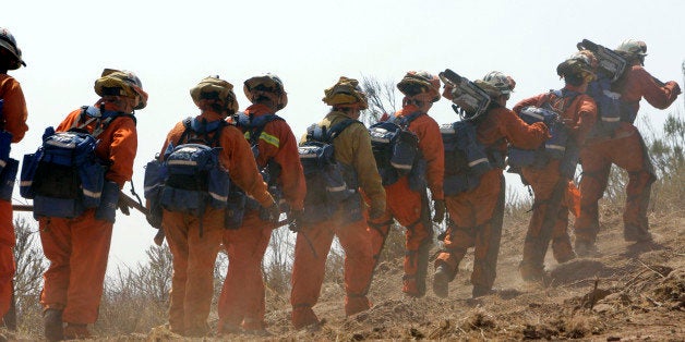 A fire crew comprised of female inmates from the California Department of Corrections and Rehabilitation's conservation camp program, march to an area in the vicinity of the Gap wildfire Tuesday, July 8, 2008, in Goleta, Calif. (AP Photo/Ric Francis)