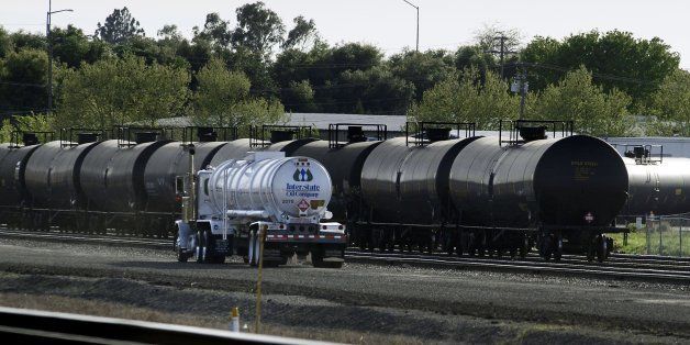 Recently filled, a tanker truck drives past railway cars containing crude oil on railroad tracks in McClellan Park in North Highlands on Wednesday, March 19, 2014. North Highlands is a suburb just outside the city limits of Sacramento, Calif. (Randall Benton/Sacramento Bee/MCT via Getty Images)