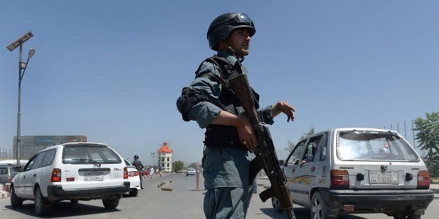 An Afghan policeman stands guard at a security checkpoint in Kabul on June 12, 2014. Afghans head to the polls June 14 for a