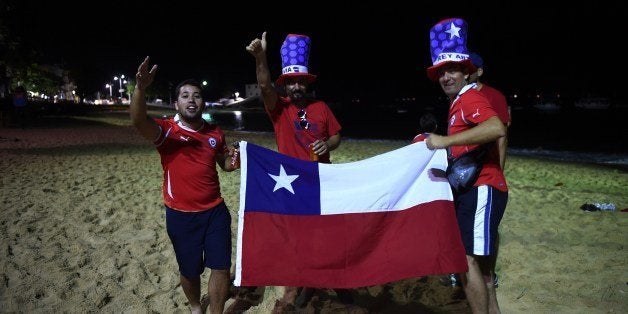 Fans of Chile celebrate on the beach in Salvador De Bahia on June 18, 2014 after the Group B football match between Spain and Chile in the Maracana Stadium in Rio de Janeiro for the 2014 FIFA World Cup. AFP PHOTO / ANNE-CHRISTINE POUJOULAT (Photo credit should read ANNE-CHRISTINE POUJOULAT/AFP/Getty Images)