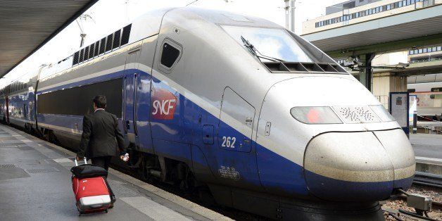A passenger walks by a high speed train at the Gare de Lyon railway station in Paris on June 16, 2014. France's longest rail strike in years entered its second week on June 16, causing major disruptions in a crucial test for President Francois Hollande's embattled Socialist government. AFP PHOTO / BERTRAND GUAY (Photo credit should read BERTRAND GUAY/AFP/Getty Images)