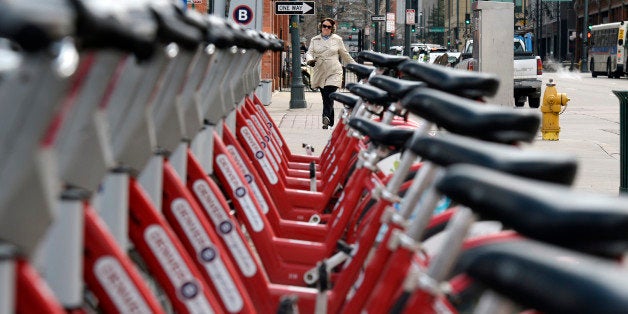 DENVER, CO - MARCH 24: The Denver B-cycle bike sharing program is doing very well. This station at 17th Street and Blake Street was photographed on Monday March 24, 2014 as a walker headed down 17th Street. (Denver Post Photo by Cyrus McCrimmon)