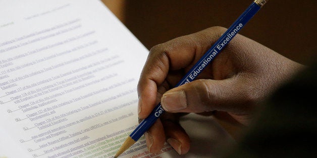 Texas Board of Education member Lawrence A. Allen Jr. uses a pencil to to mark and follow proposals related to algebra II, Thursday, Nov. 21, 2013, in Austin, Texas. The Board of Education is casting critical votes on new science textbooks for use statewide, and on whether algebra II should be a required high school course.(AP Photo/Eric Gay)