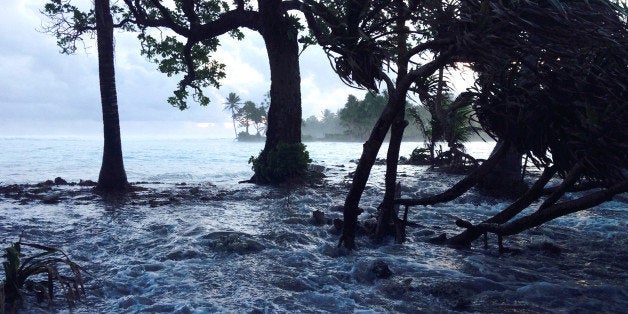 A high tide energized by storm surges washes across Ejit Island in Majuro Atoll, Marshall Islands on March 3, 2014, causing widespread flooding and damaging a number of homes. Officials in the Marshall Islands blamed climate change on March 5, 2014, for severe flooding in the Pacific nation's capital Majuro which has left 1,000 people homeless. Climate change is a major concern for Pacific island states such as the Marshals, Kiribati and Tuvalu, where many atolls are barely a metre (three feet) above sea level and risk being engulfed by rising waters. AFP PHOTO/GIFF JOHNSON (Photo credit should read GIFF JOHNSON/AFP/Getty Images)