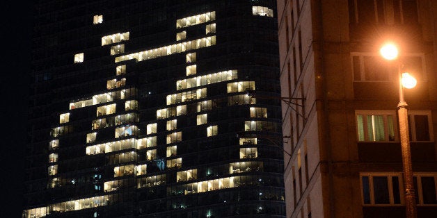 Some of the offices of a building have the lights on to shape a bicycle in downtown Warsaw on March 23, 2013, as iconic landmarks and skylines are plunged into darkness as the 'Earth Hour' switch-off of lights around the world got under way to raise awareness of climate change. AFP PHOTO/JANEK SKARZYNSKI (Photo credit should read JANEK SKARZYNSKI/AFP/Getty Images)