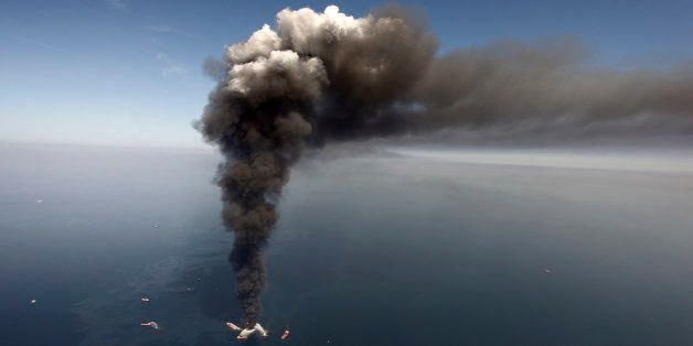 FILE - In this Wednesday, April 21, 2010 file photo, oil can be seen in the Gulf of Mexico, more than 50 miles southeast of Venice on Louisiana's tip, as a large plume of smoke rises from fires on BP's Deepwater Horizon offshore oil rig. An April 20, 2010 explosion at the offshore platform killed 11 men, and the subsequent leak released an estimated 172 million gallons of petroleum into the gulf. U.S. District Judge Carl Barbier ruled Thursday, Sept. 4, 2014, in New Orleans, La., that BP acted recklessly and bears most of the responsibility for the oil spill. The ruling exposes BP to about $18 million in civil fines under the Clean Water Act. (AP Photo/Gerald Herbert, File)