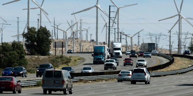 PALM SPRINGS, CA - MARCH 27: Automobiles pass by giant wind turbines powered by strong winds on March 27, 2013 in Palm Sprin