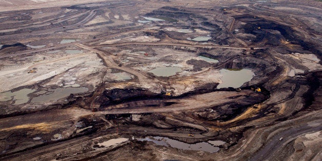 The Syncrude Canada Ltd. base plant stands in this aerial photograph taken above the Athabasca Oil Sands near Fort McMurray, Alberta, Canada, on Wednesday, June 19, 2014. Heavy crude from the oil sands has traded at an average of $18.70 per barrel below the U.S. benchmark over the last five years due to a transportation bottleneck in North America. The discount costs Canadas economy as much as C$50 million per day, according to the Canadian Chamber of Commerce. Photographer: Ben Nelms/Bloomberg via Getty Images