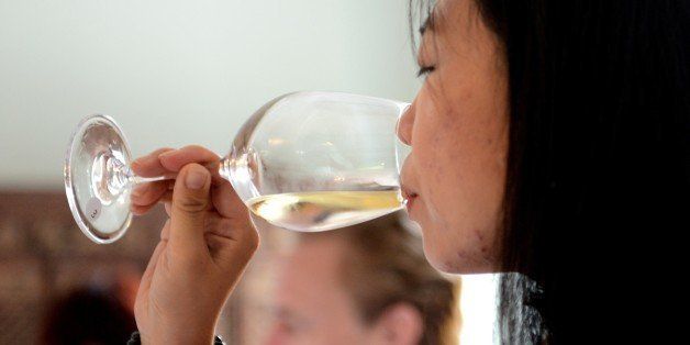 A wine judge tastes a selected Ningxia wine at a large tasting event in Beijing on September 25, 2014. Ningxia wine has gone from an unknown remote region to one of the most talked about wine places on the planet, partly because, as part of a government-backed project, several foreign winemakers lived in Ningxia and each made a red or white wine. AFP PHOTO/GOH CHAI HIN (Photo credit should read GOH CHAI HIN/AFP/Getty Images)